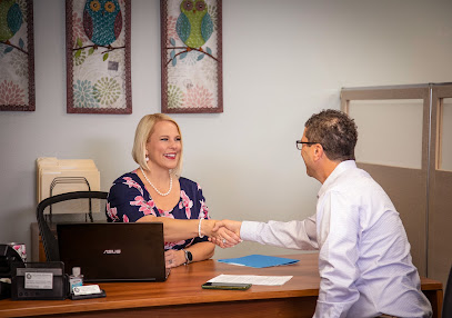 Business owner shaking hands with a consultant during a meeting at an office desk